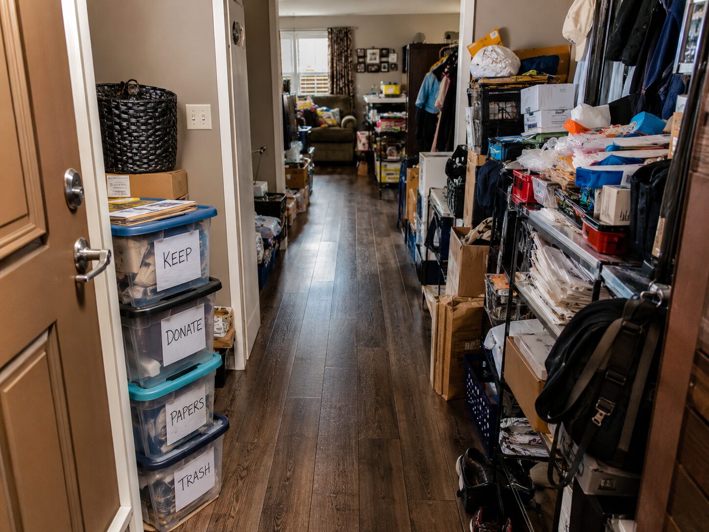 Cheminement sécurisé créé dans un logement encombré avec un passage dégagé entre des piles d’objets avant évacuation