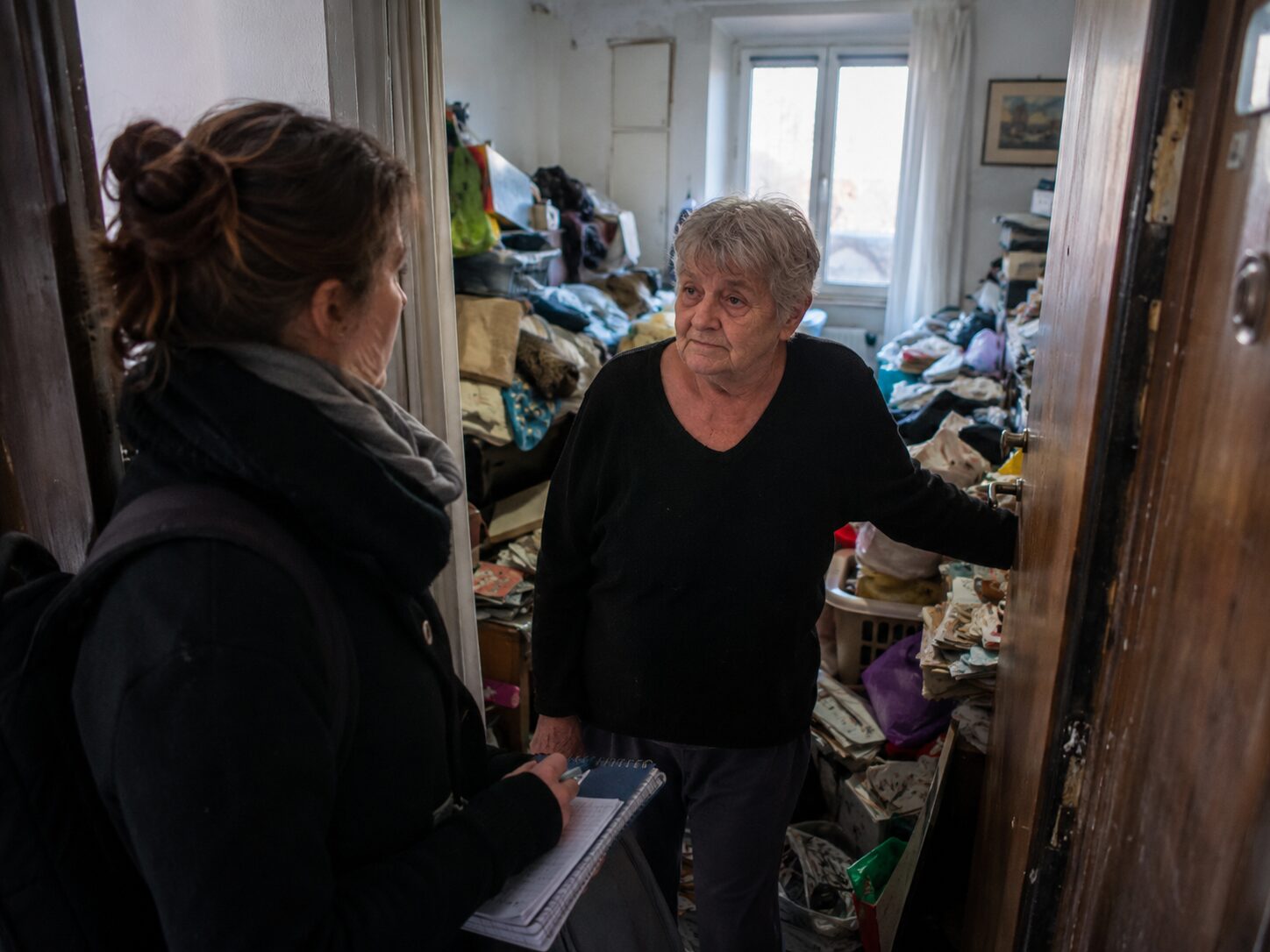 Professionnelle accompagnant une personne âgée dans un logement encombré lors d’une intervention en incurie avec refus du changement