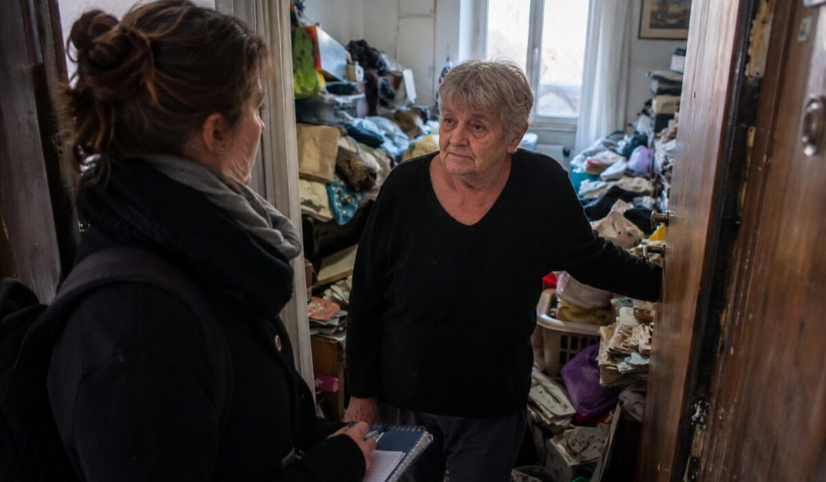 Professionnelle accompagnant une personne âgée dans un logement encombré lors d’une intervention en incurie avec refus du changement