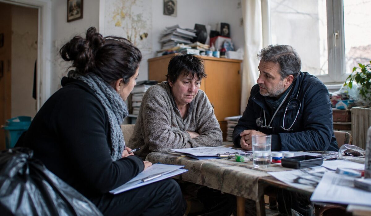 Professionnels médico-sociaux accompagnant une personne en situation d’incurie lors d’une visite à domicile dans un logement encombré